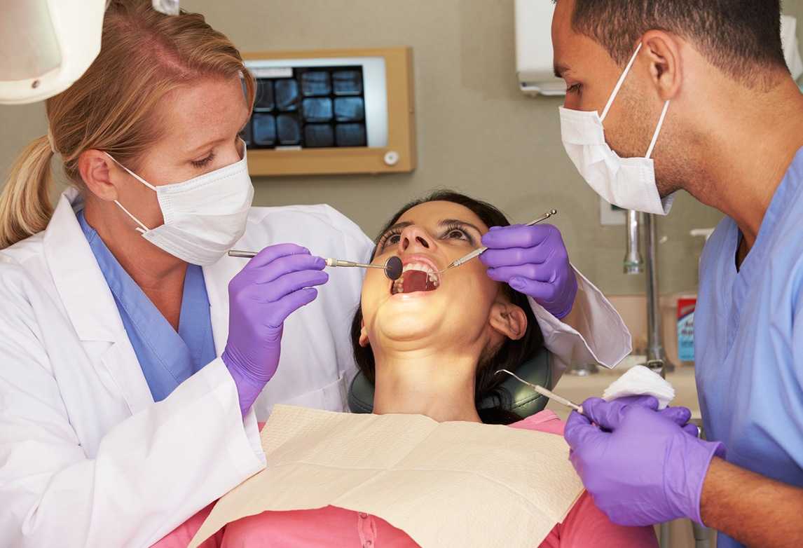 A dental assistant working with a patient