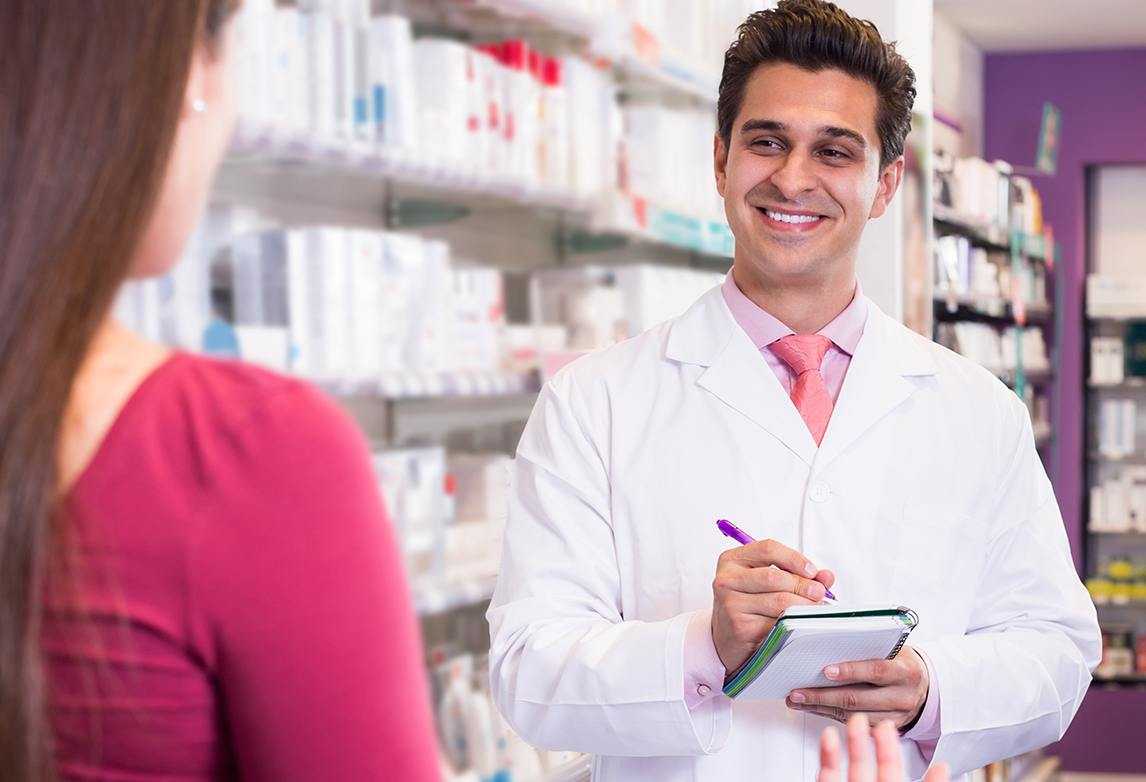 A pharmacy technician interacts with a customer.