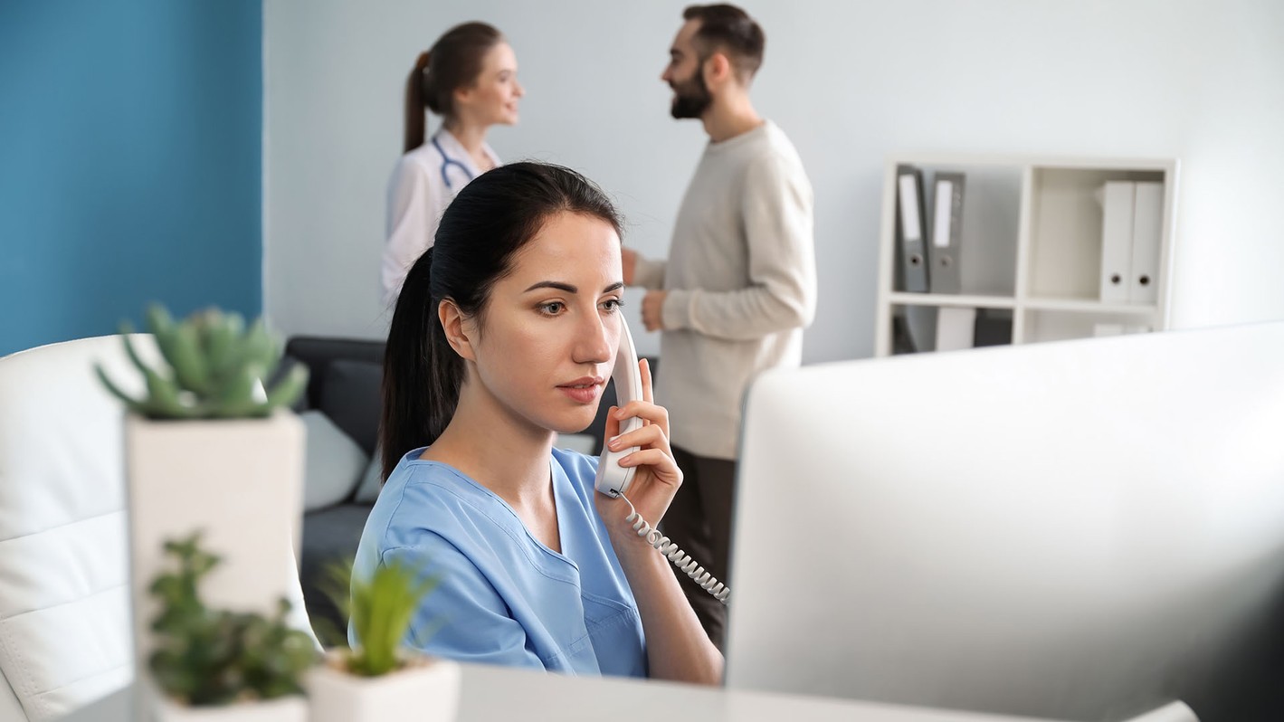 A medical biller and coder works in the field helping a customer over the phone after completing one of UMA's online medical billing and coding programs.